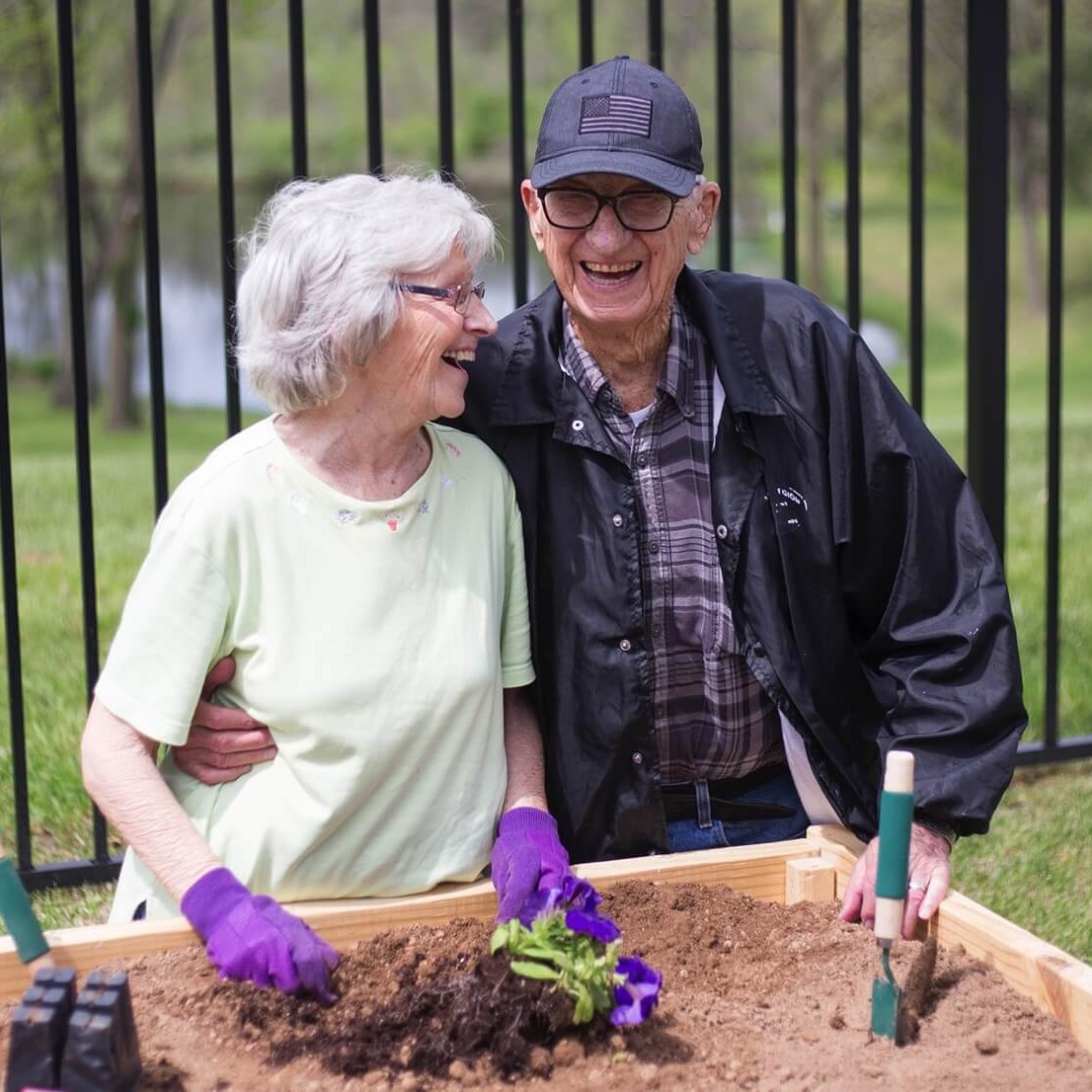Resident couple smiling and gardening