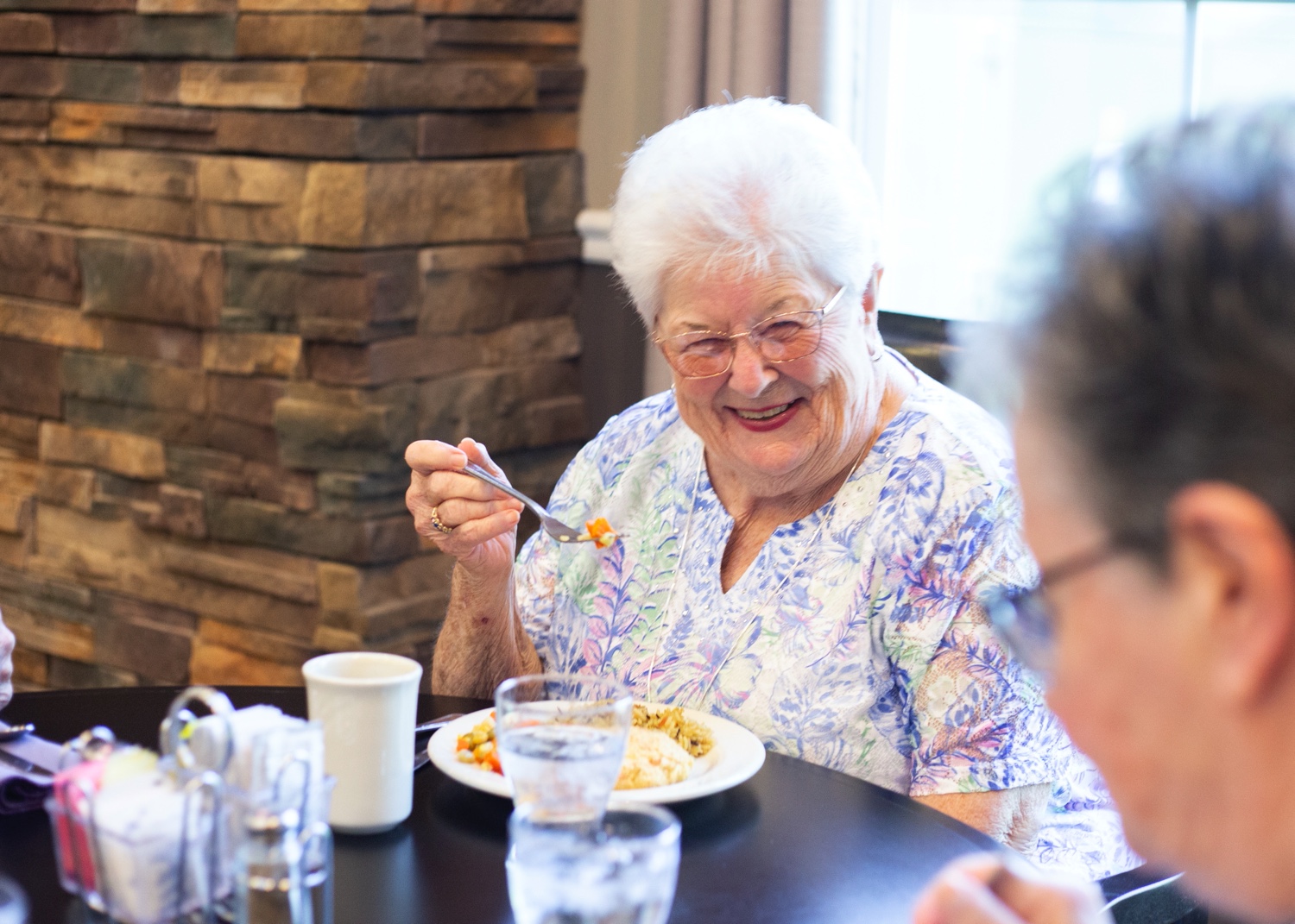 Residents smiling and enjoying breakfast together