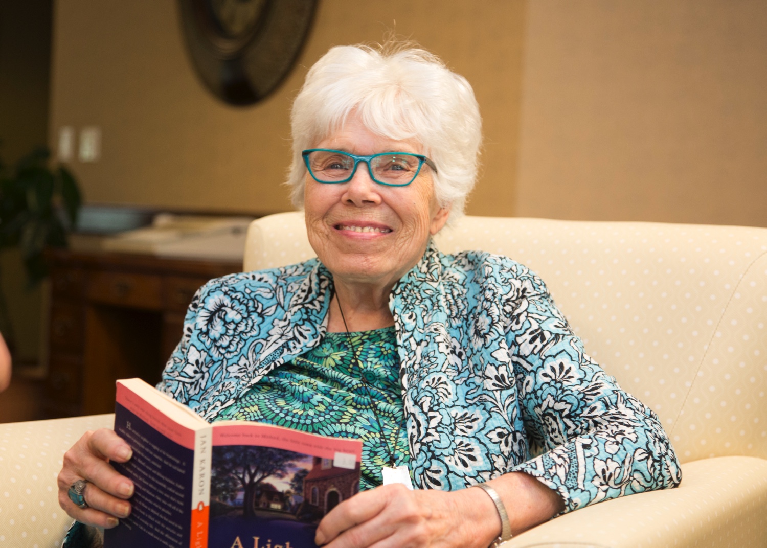 Senior living community resident reading and smiling