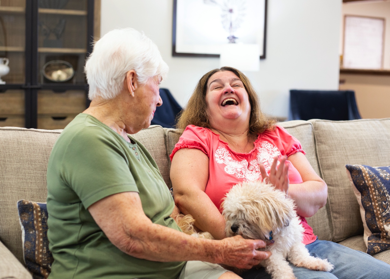 Two Resident Women On Couch With Dog