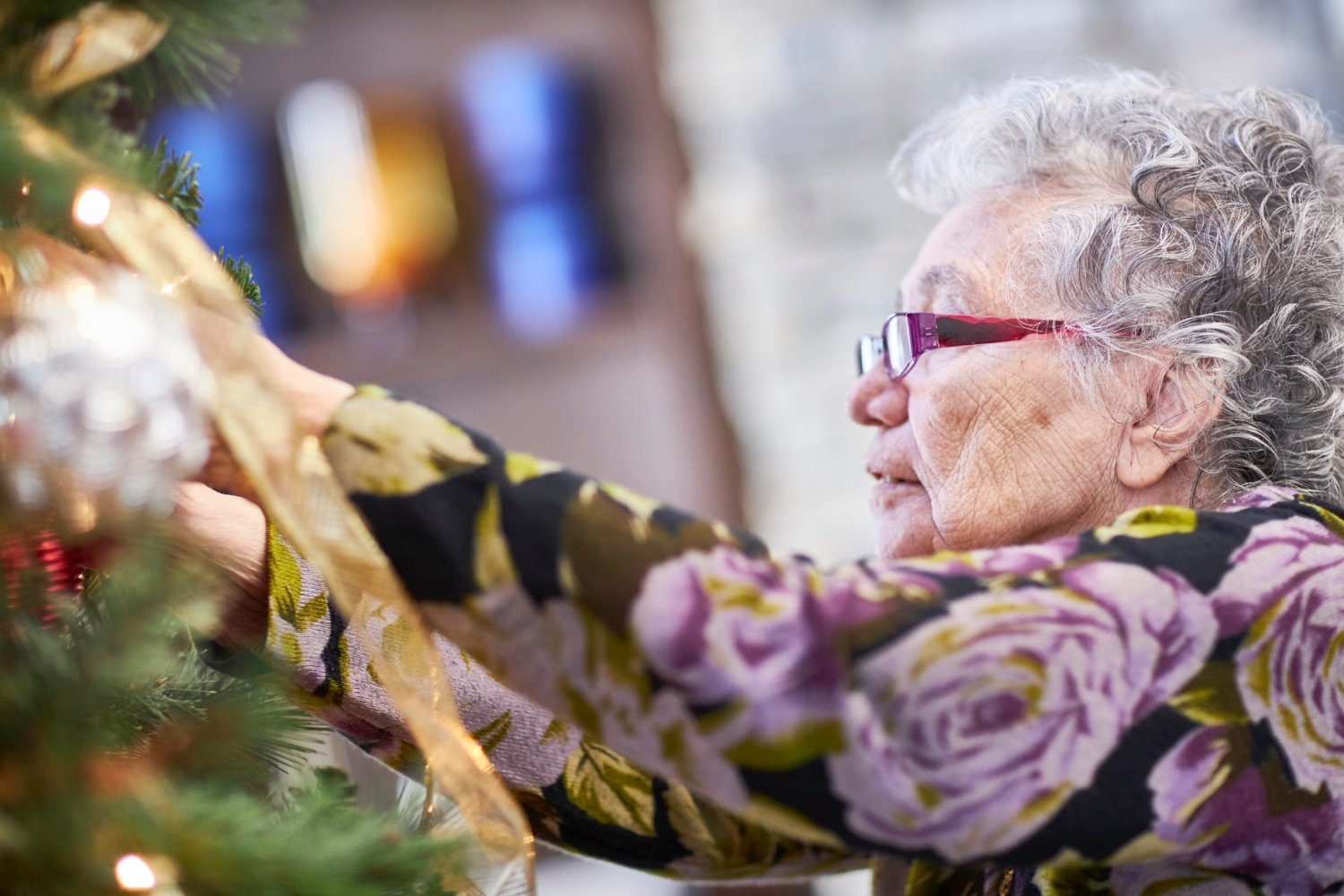 Senior lady decorating a Christmas tree