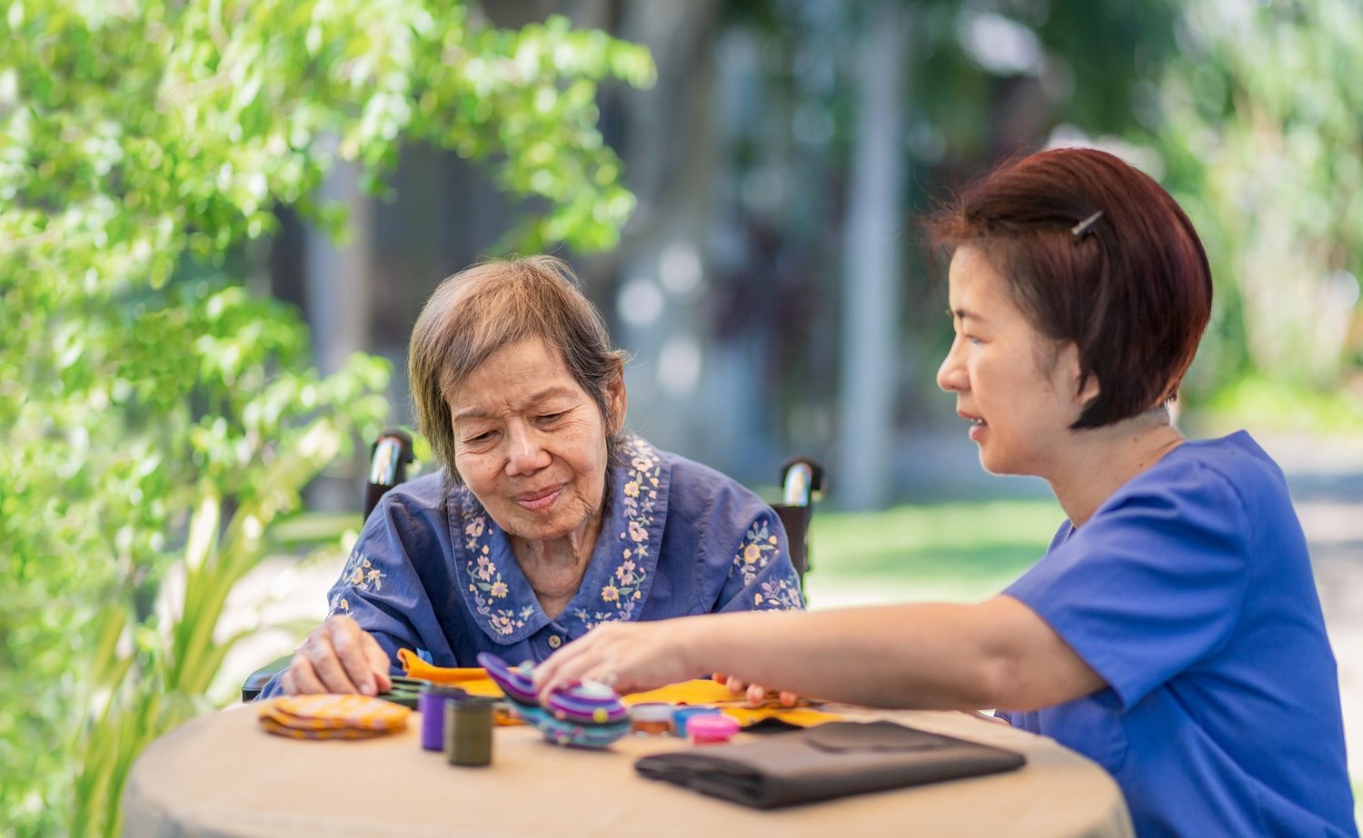 Elderly woman with caregiver in occupational therapy for dementia-1229233965