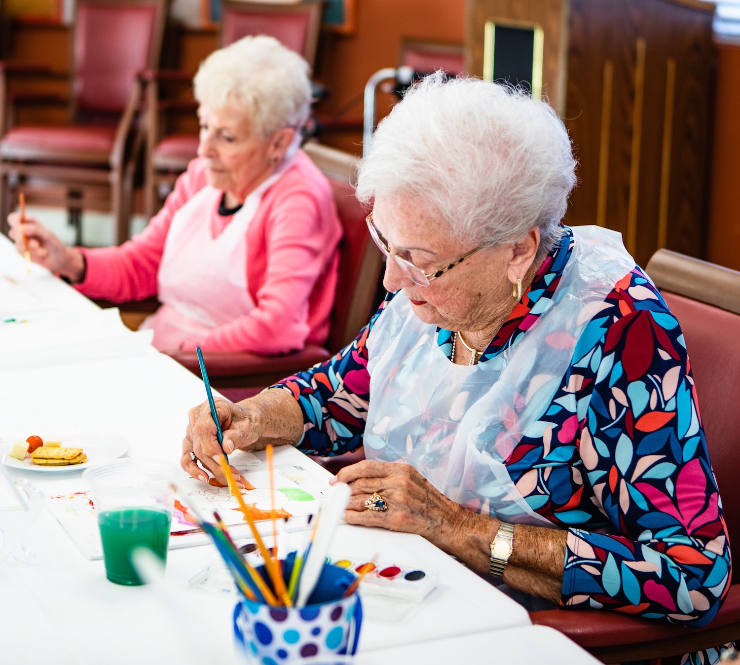 Senior women painting in class