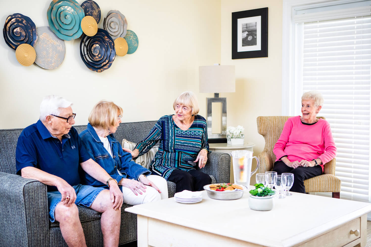 A group of seniors socializing in a private living room