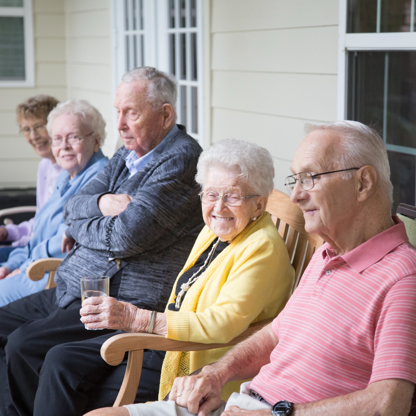 Group of residents sitting together on front porch