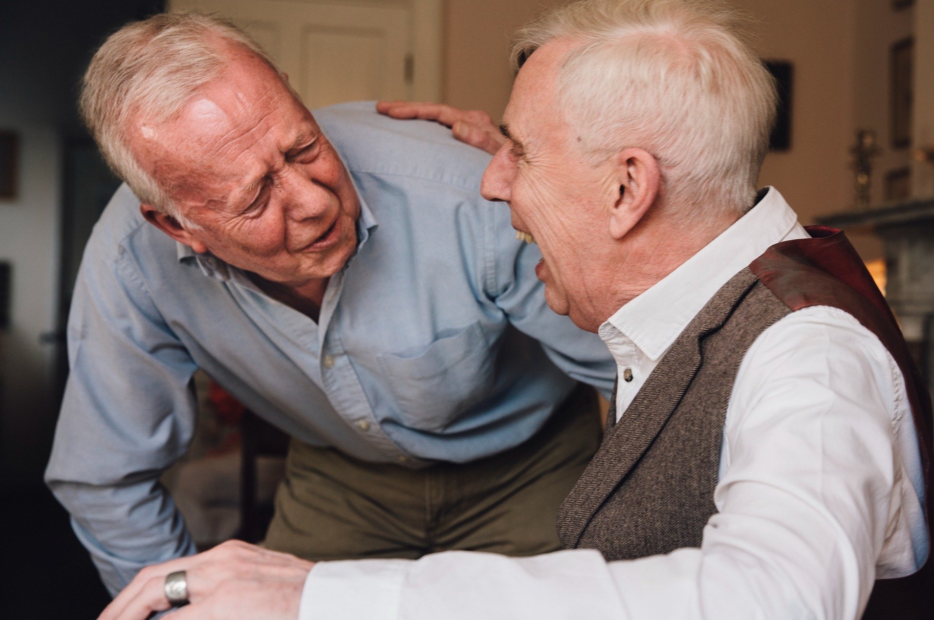 Two senior men laughing and chatting