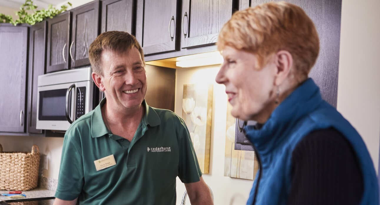 A staff member chatting with a resident in a kitchen