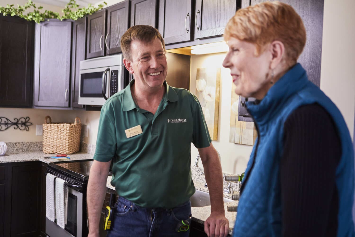 A staff maintenance worker chatting with a senior resident