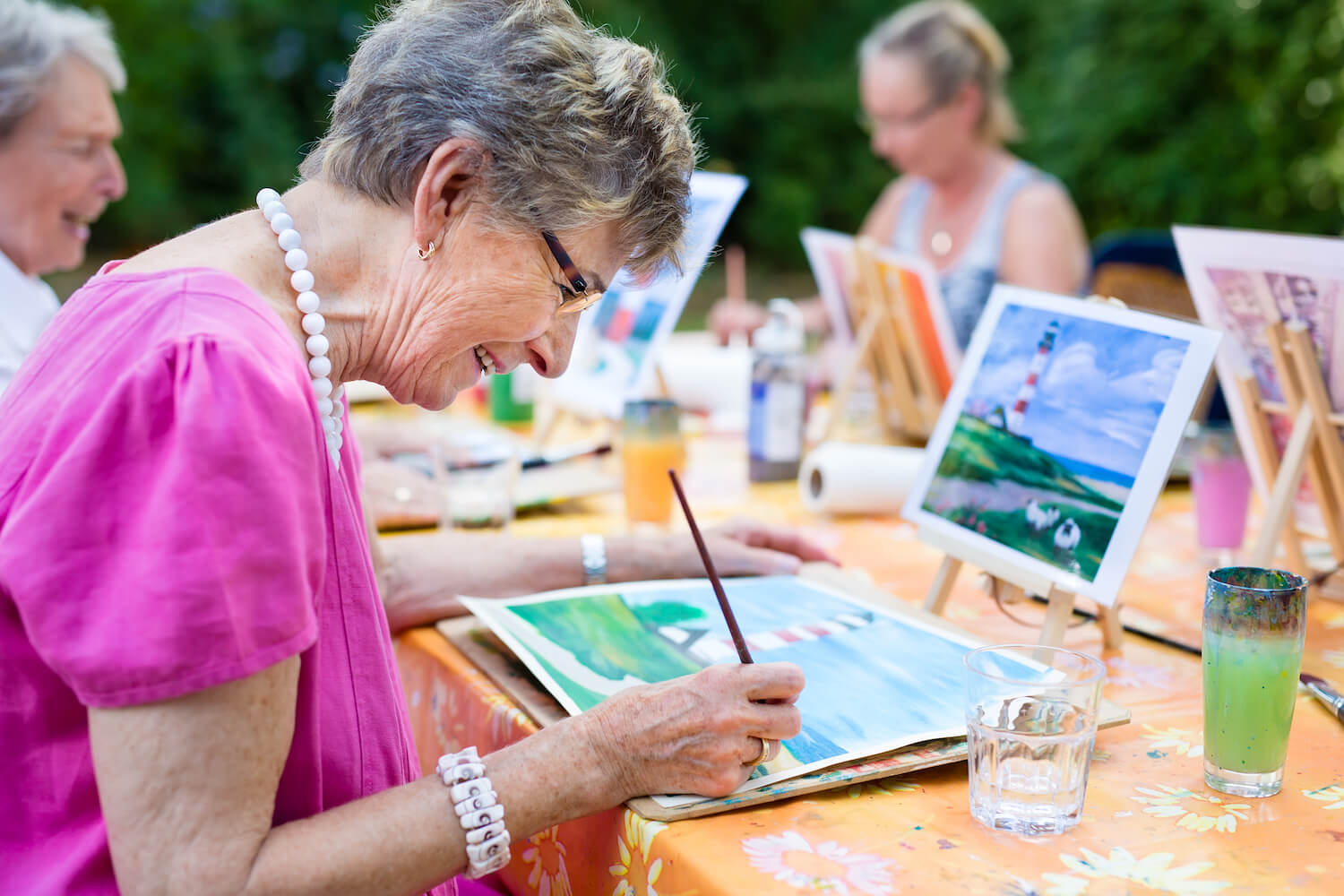 Seniors taking painting class outdoors