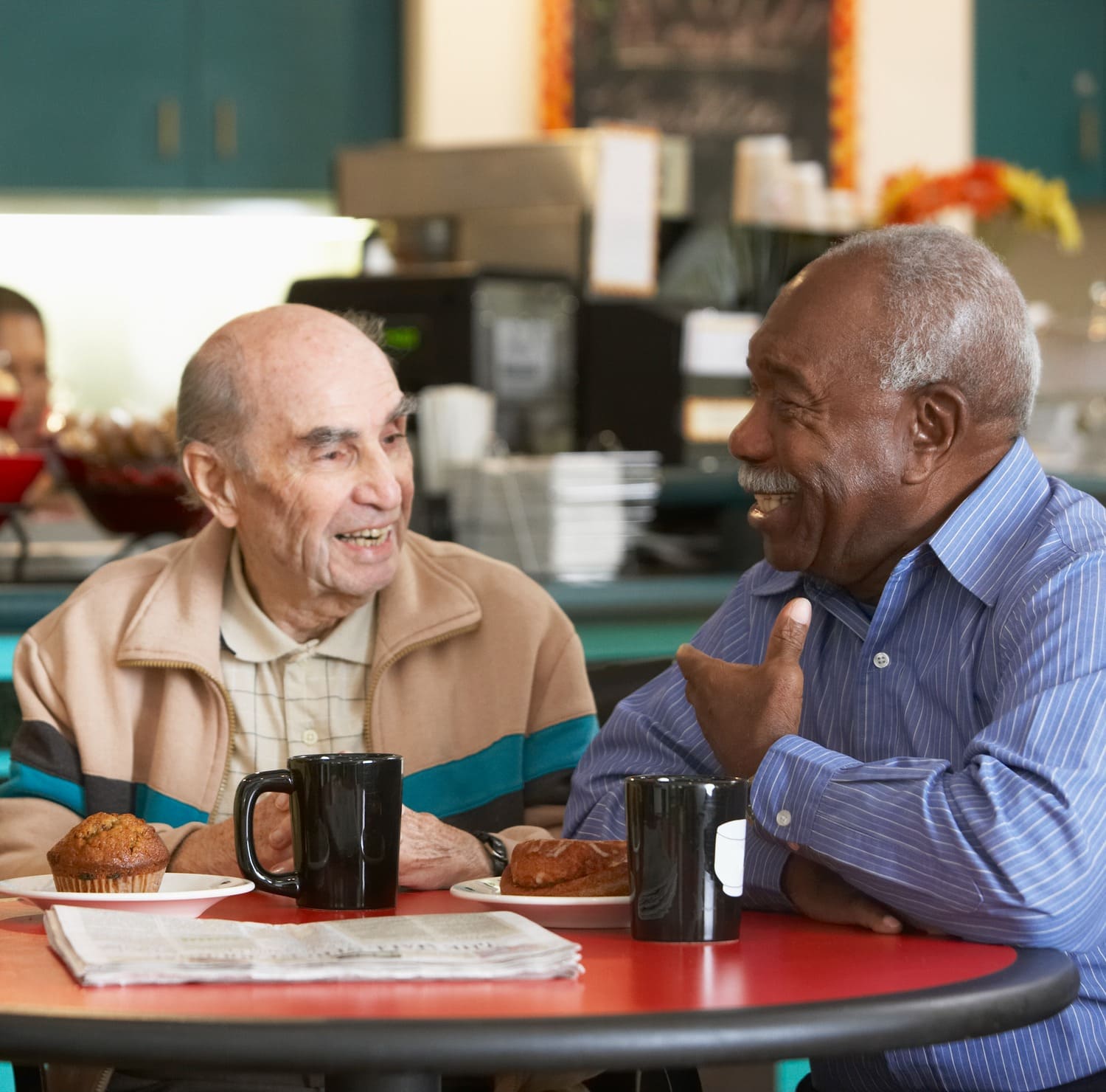 Two residents laughing together over coffee