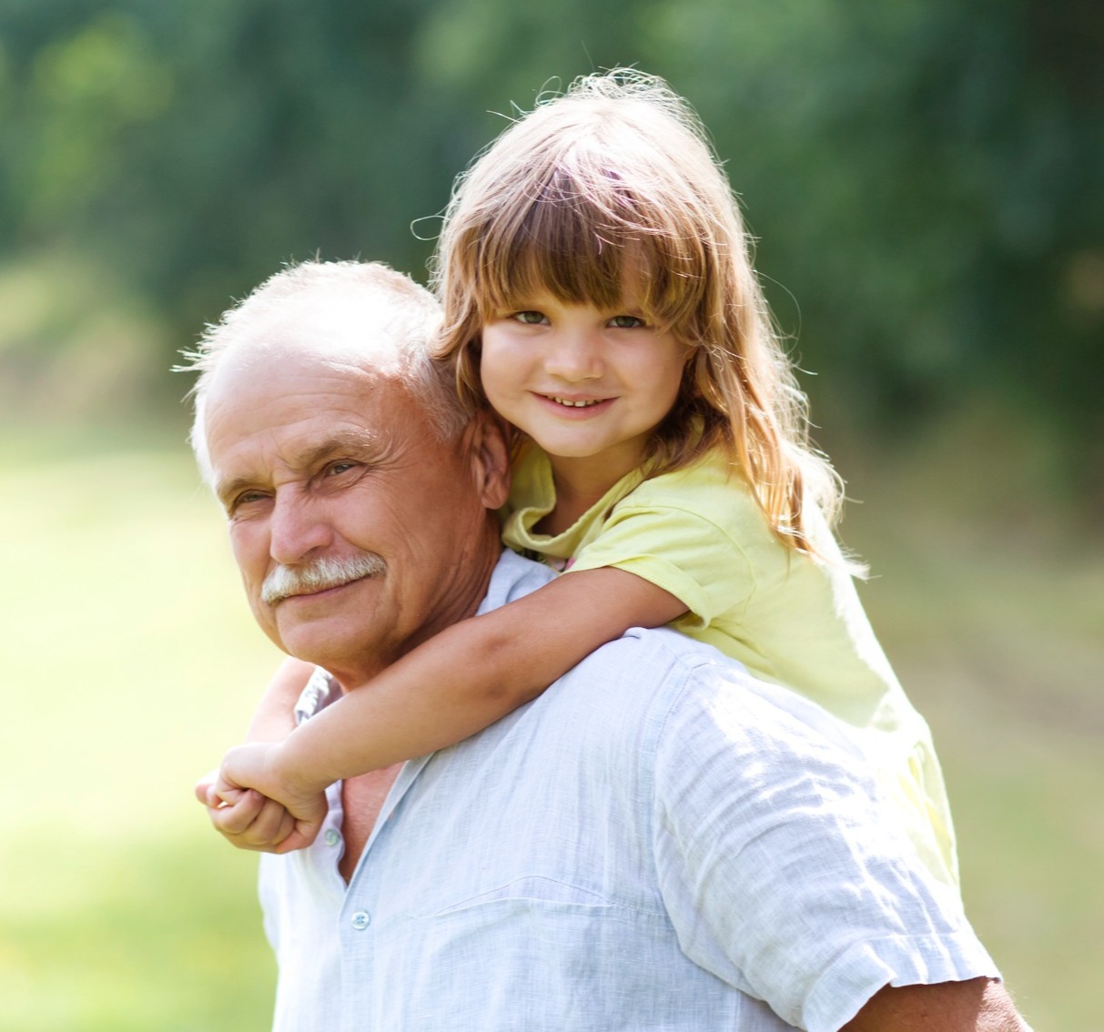 A grandfather giving his granddaughter a piggyback ride