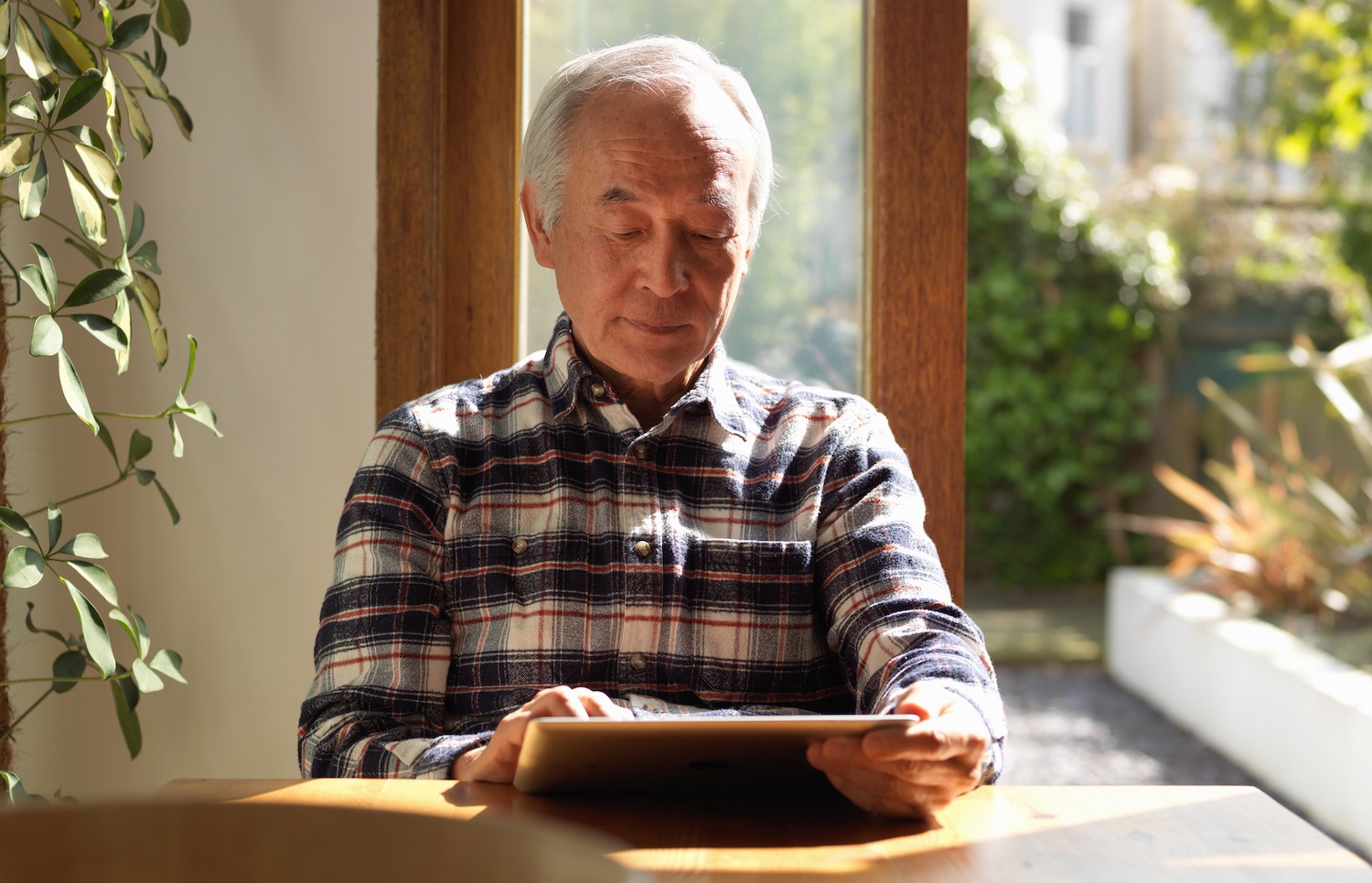 Senior man reading on a digital tablet