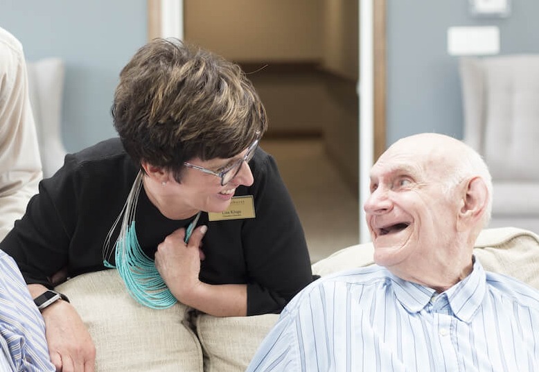 Staff member laughing with senior man