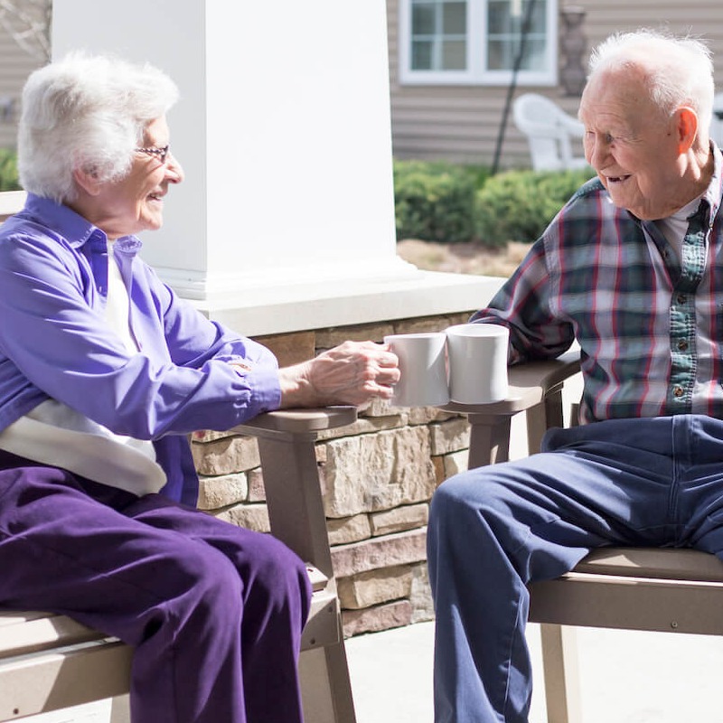 two seniors enjoying coffee outside