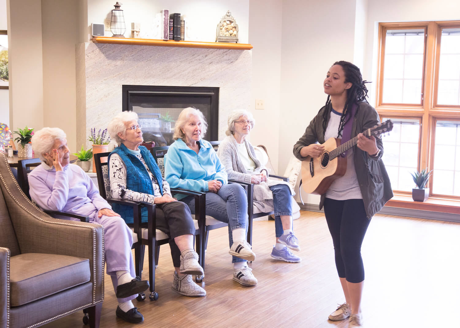 seniors watching woman play guitar