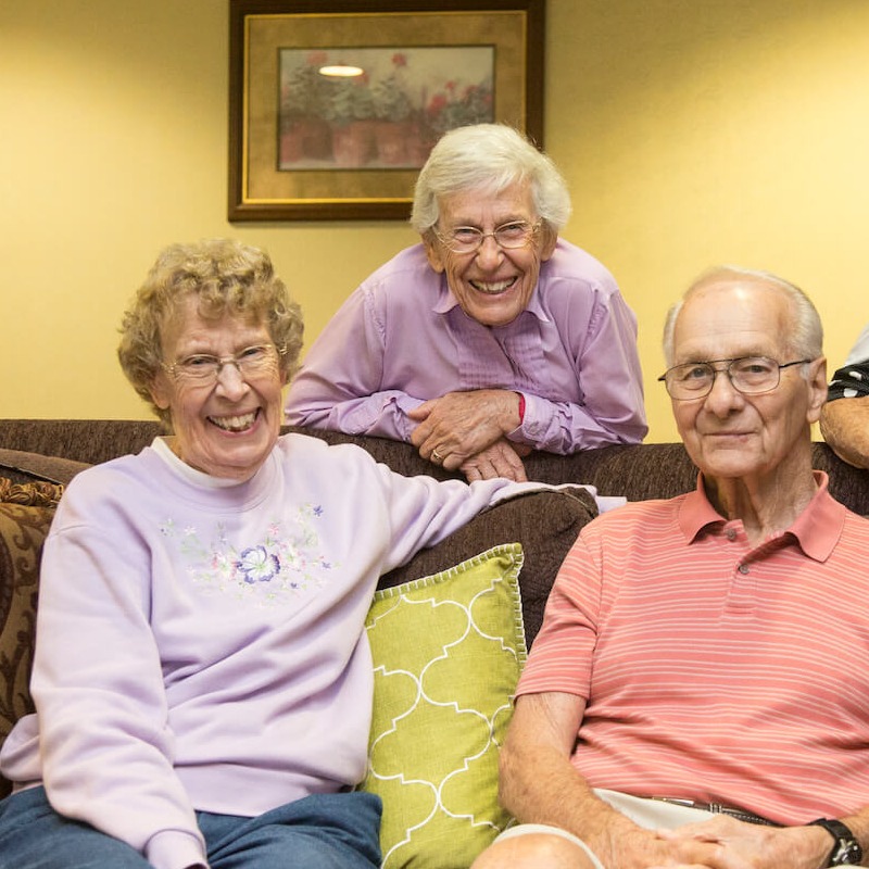 Residents smiling on a couch together