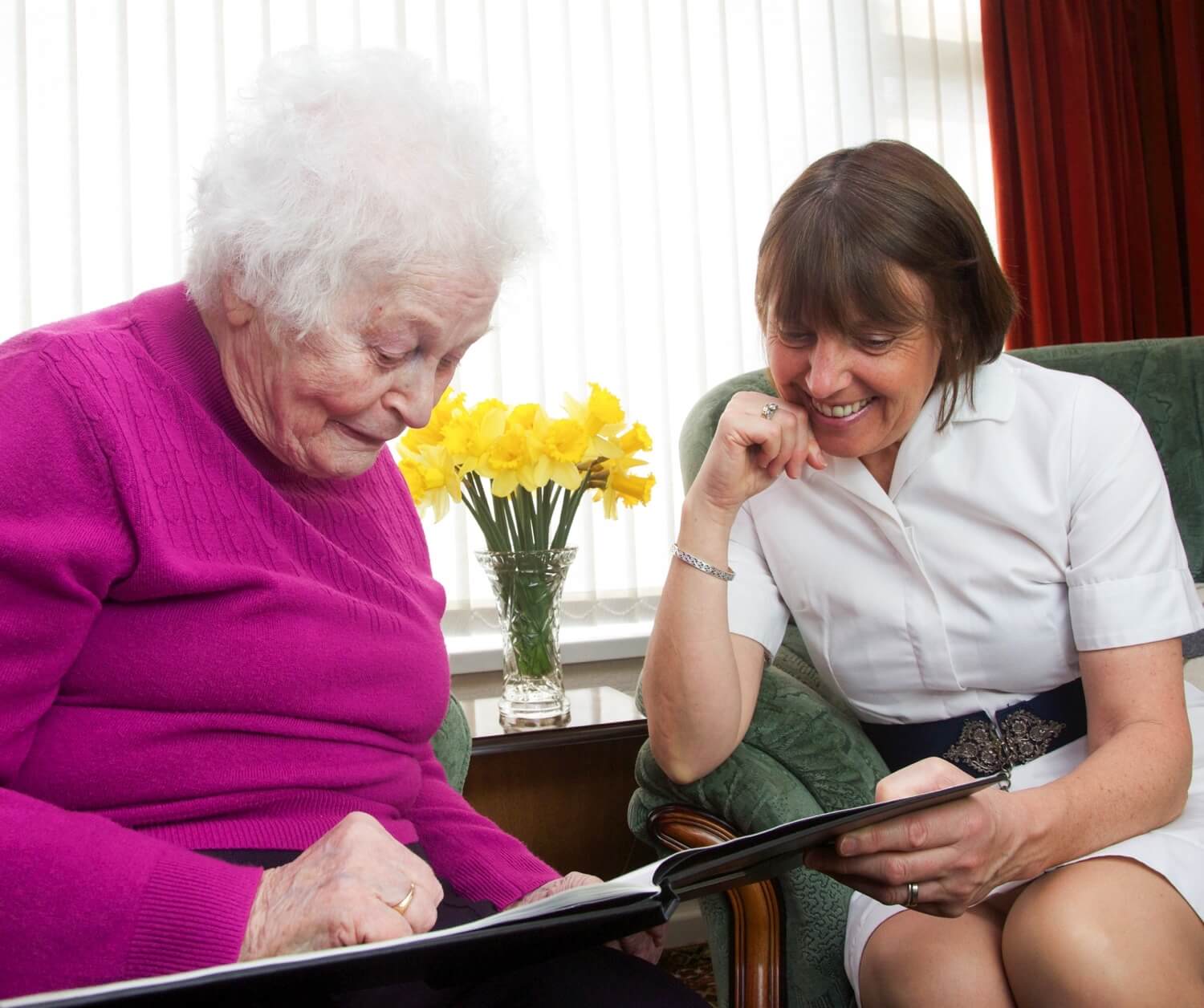 Staff member reading with senior woman