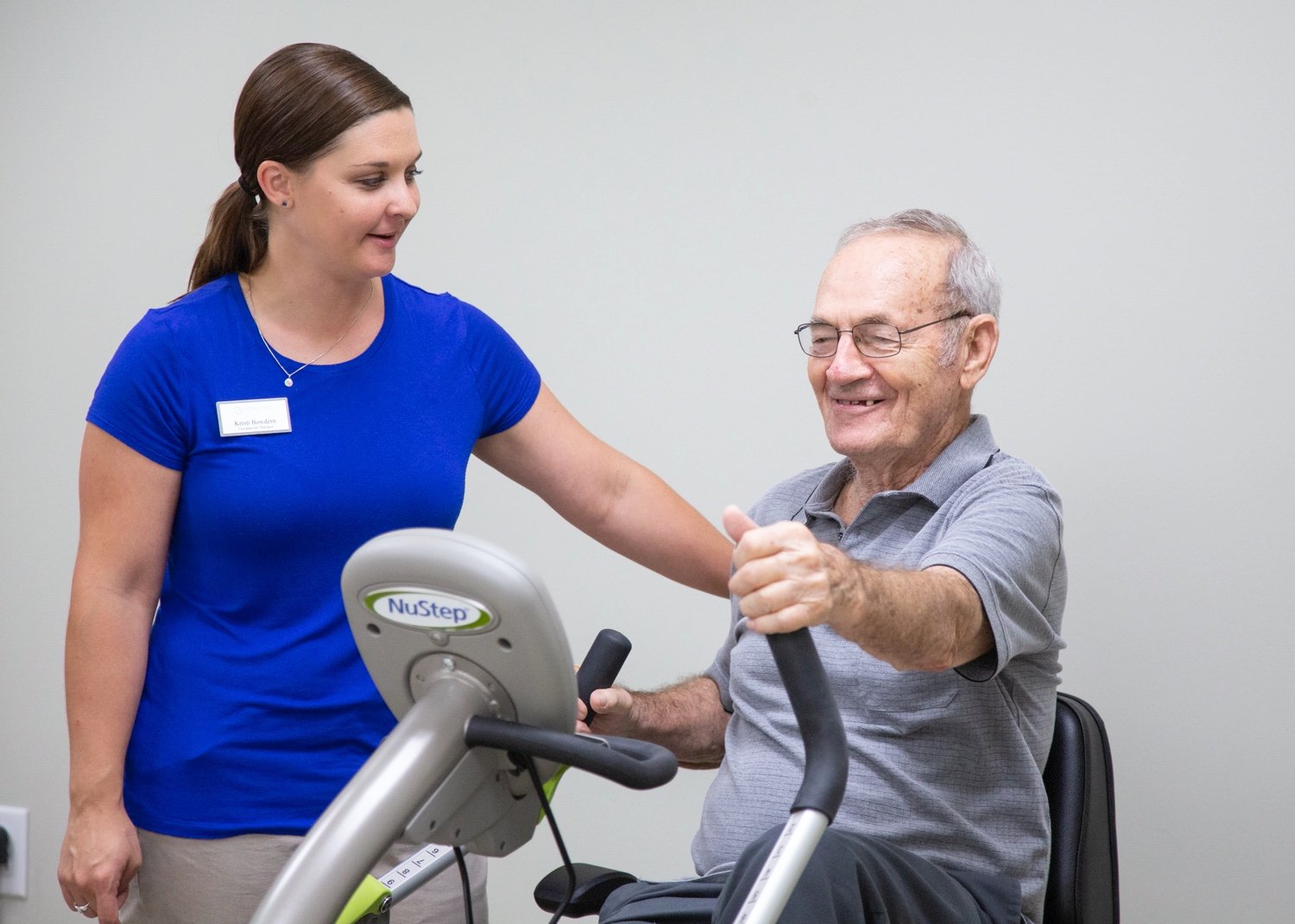 Staff member helping senior man during physical therapy