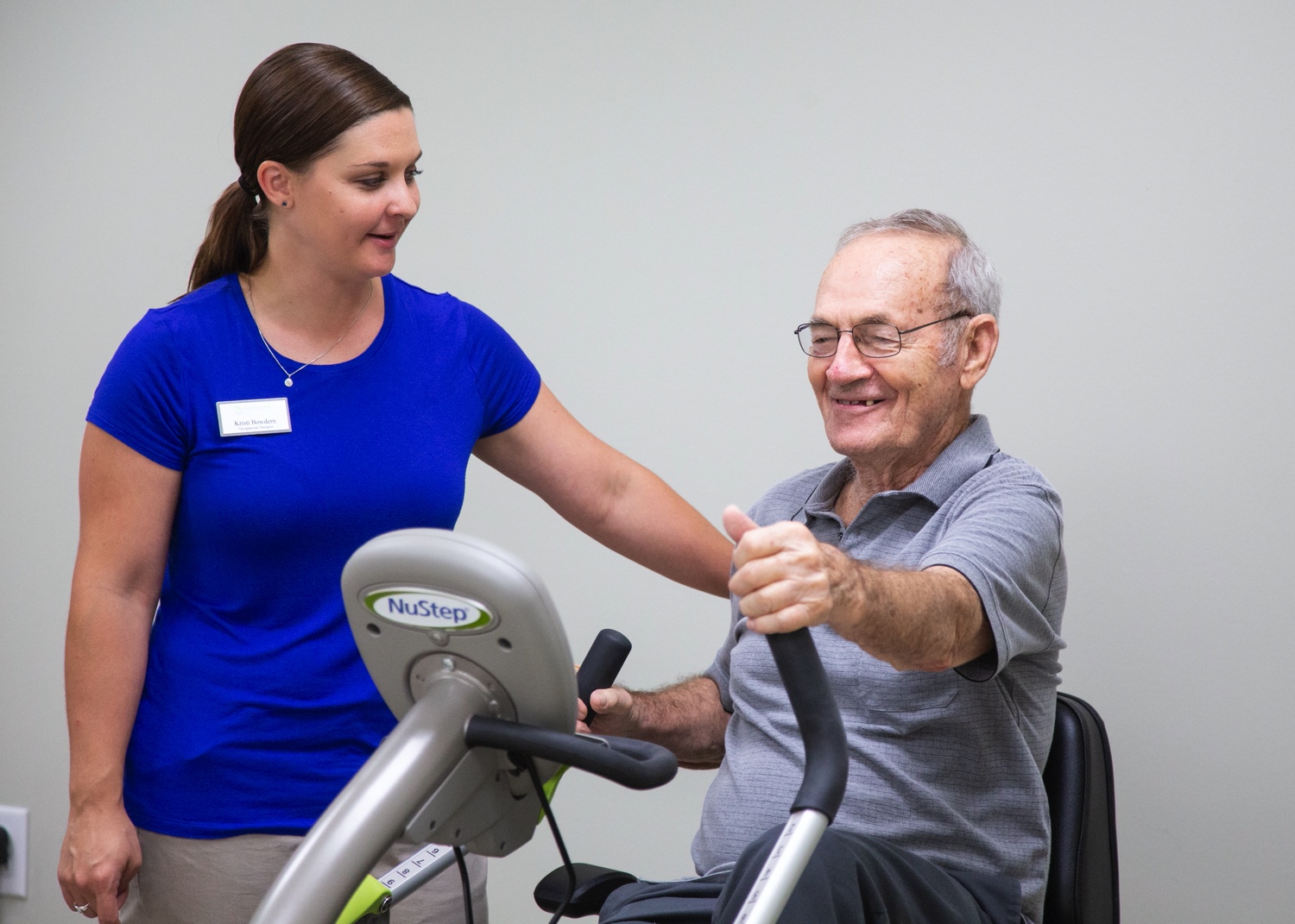 Staff member helping senior man during physical therapy