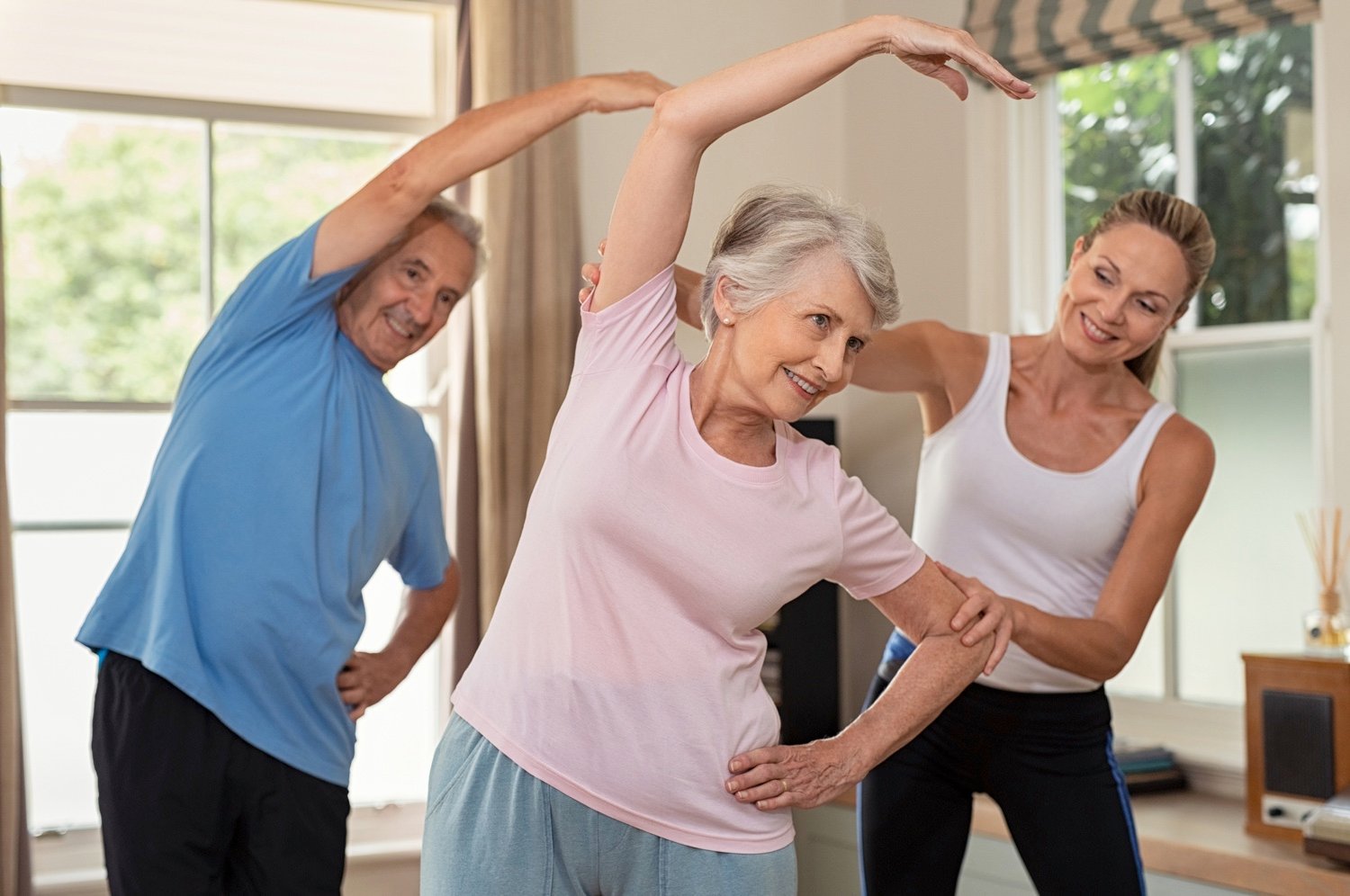 Physiotherapist helping senior couple exercise