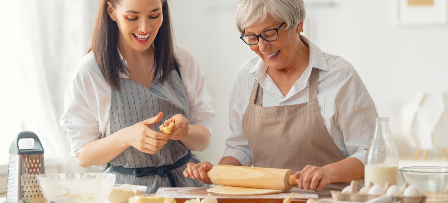 Senior and staff member baking