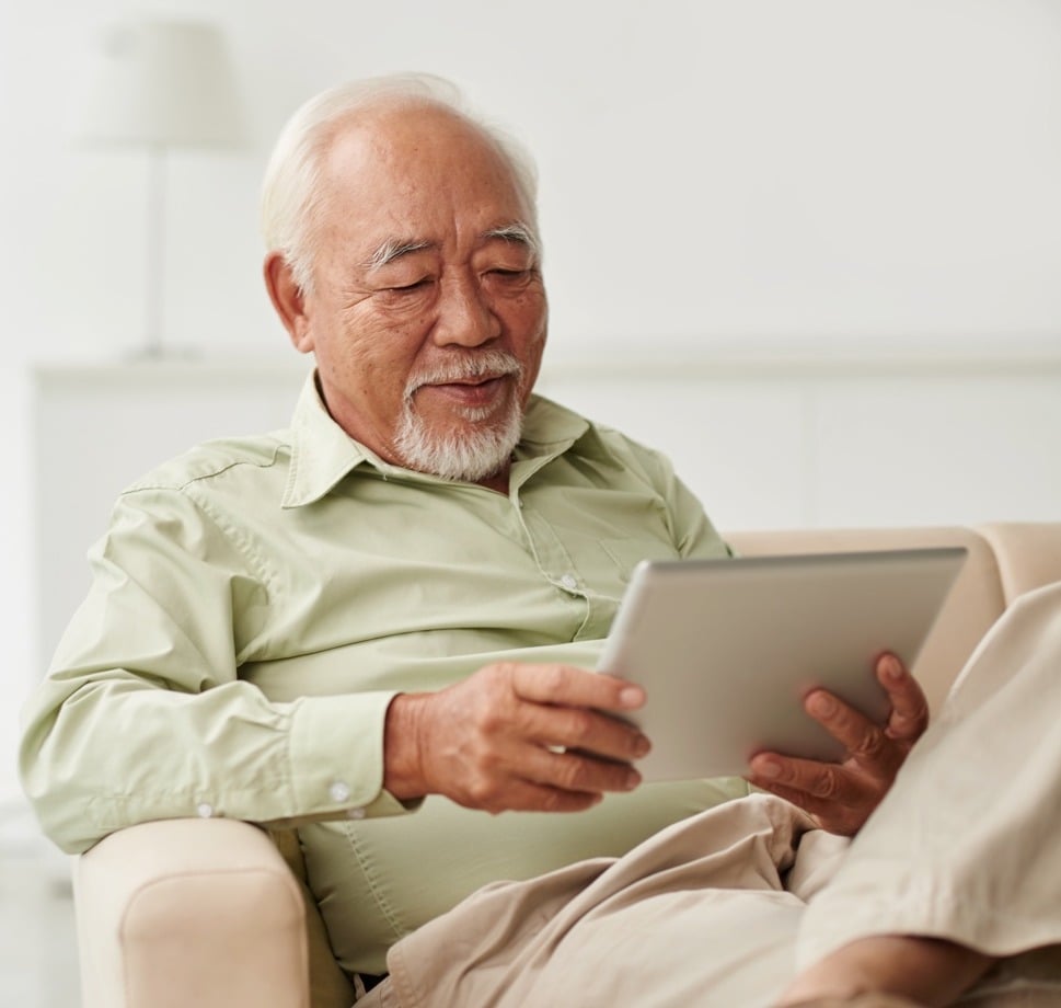 Senior man reading the news on a digital tablet