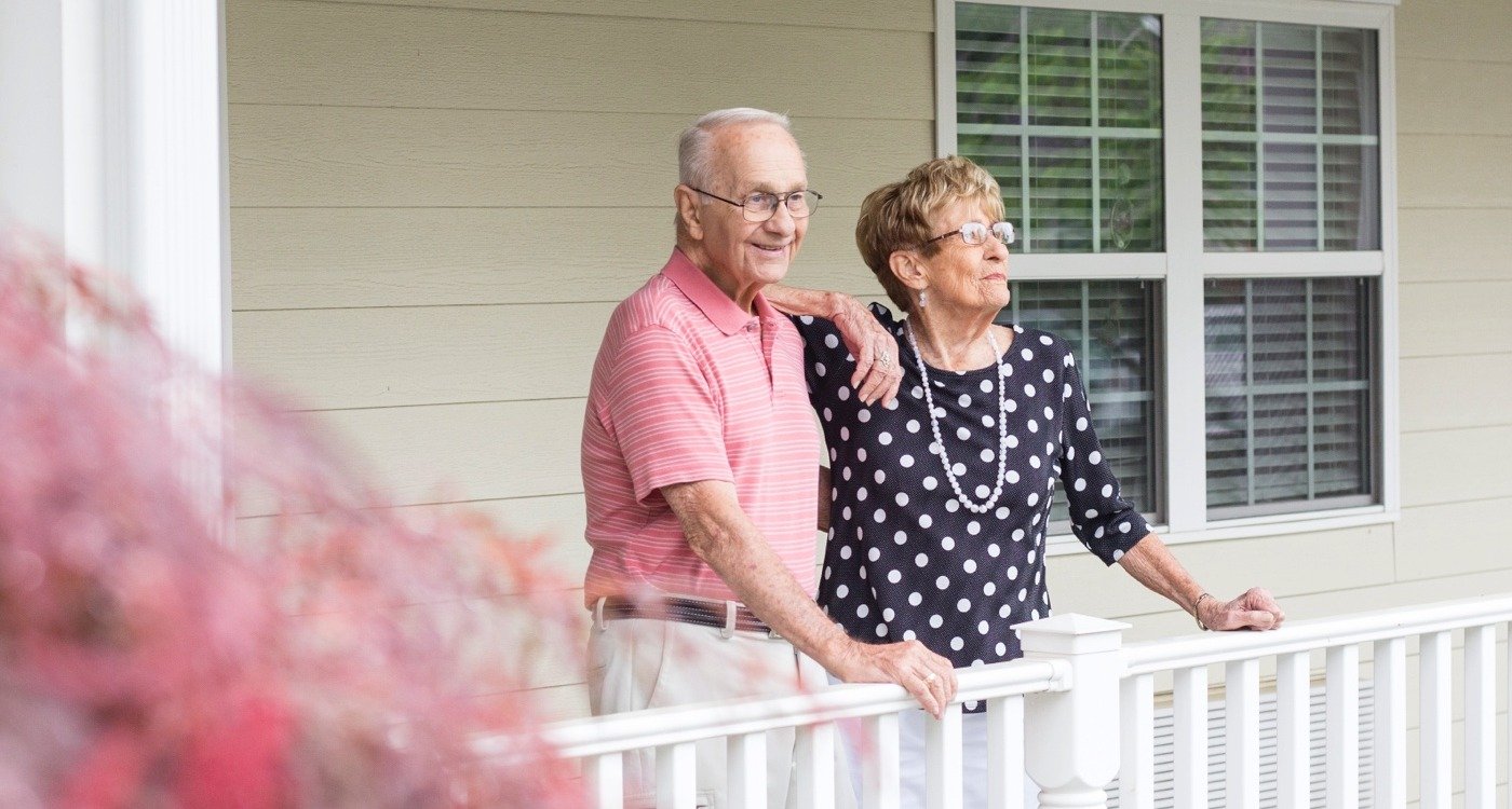 Senior couple standing on front porch