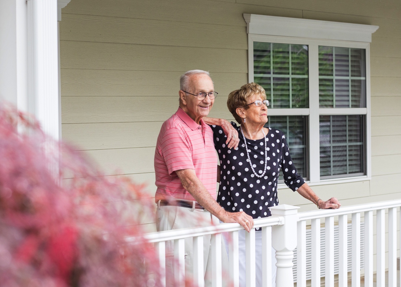 Senior couple standing on front porch