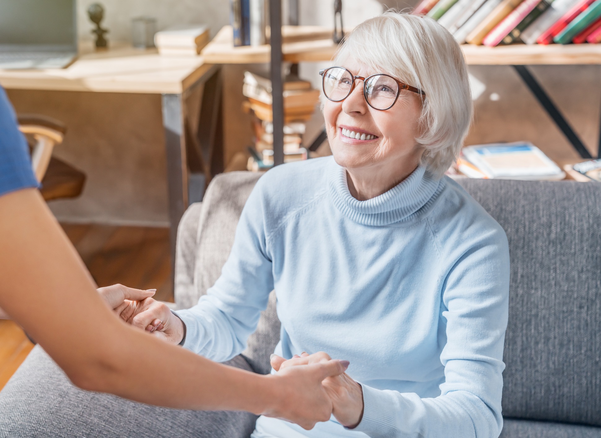 Senior holding hands with staff member