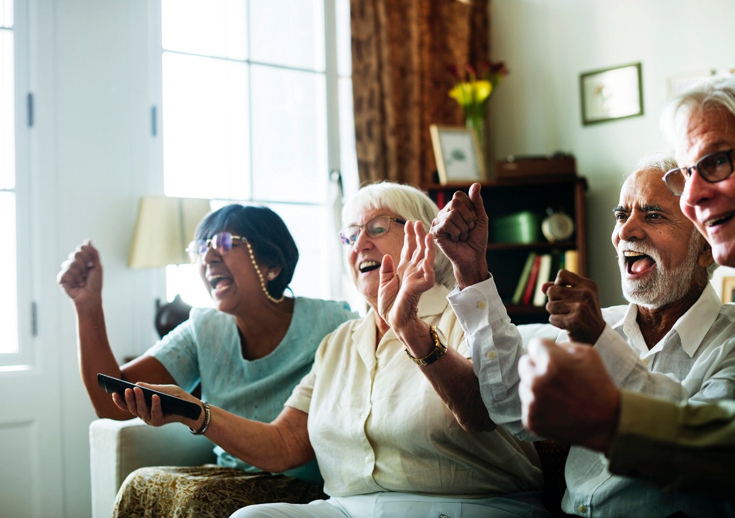 Senior people watching television together
