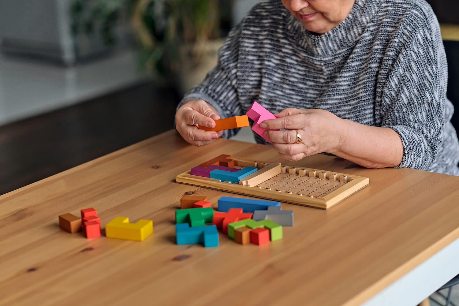 A senior resident solving a wooden shape puzzle