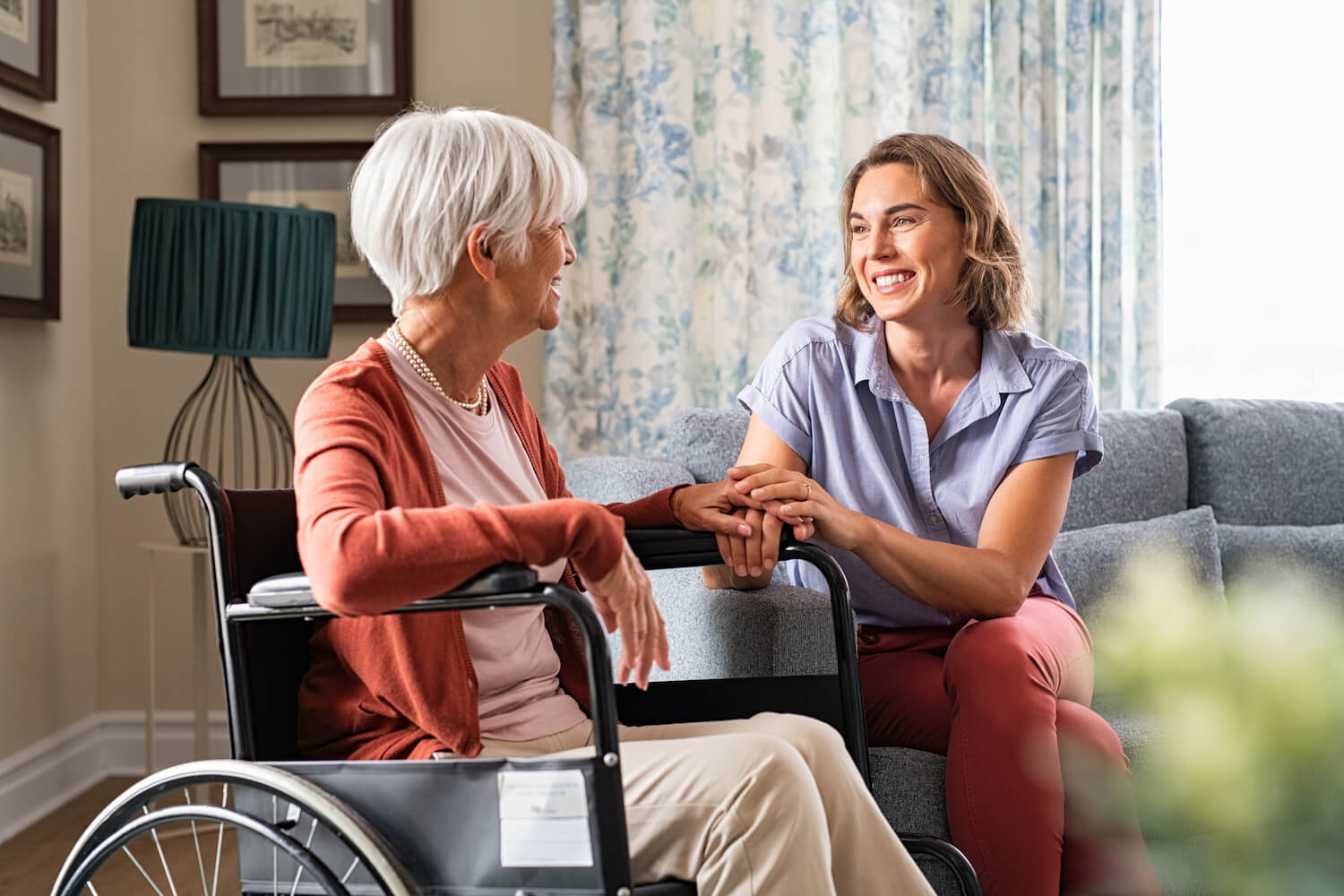 staff member talking with senior woman in a wheelchair