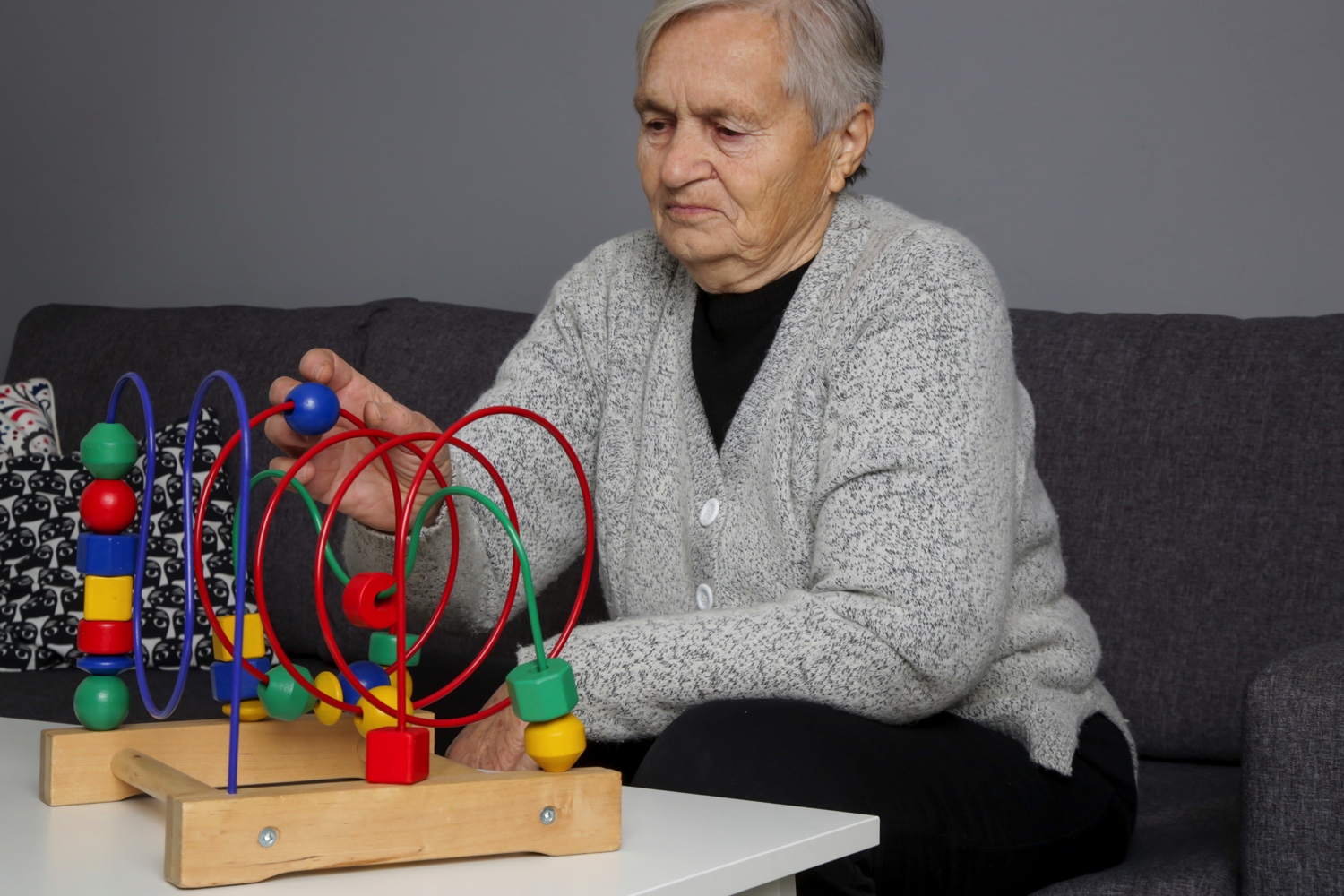 Senior woman playing with a sensory-stimulating toy to prevent dementia
