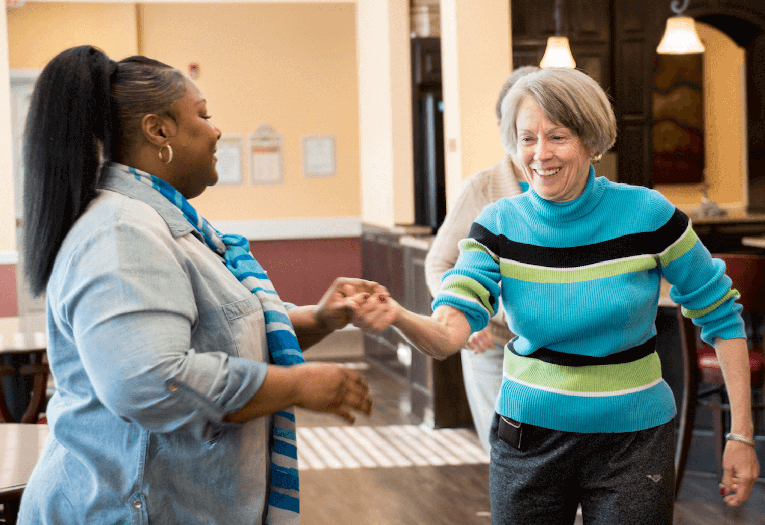 A senior woman dancing with a staff member