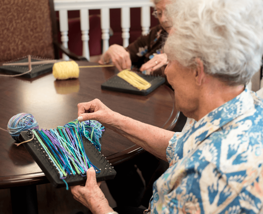 A woman participating in a group class with a yarn activity