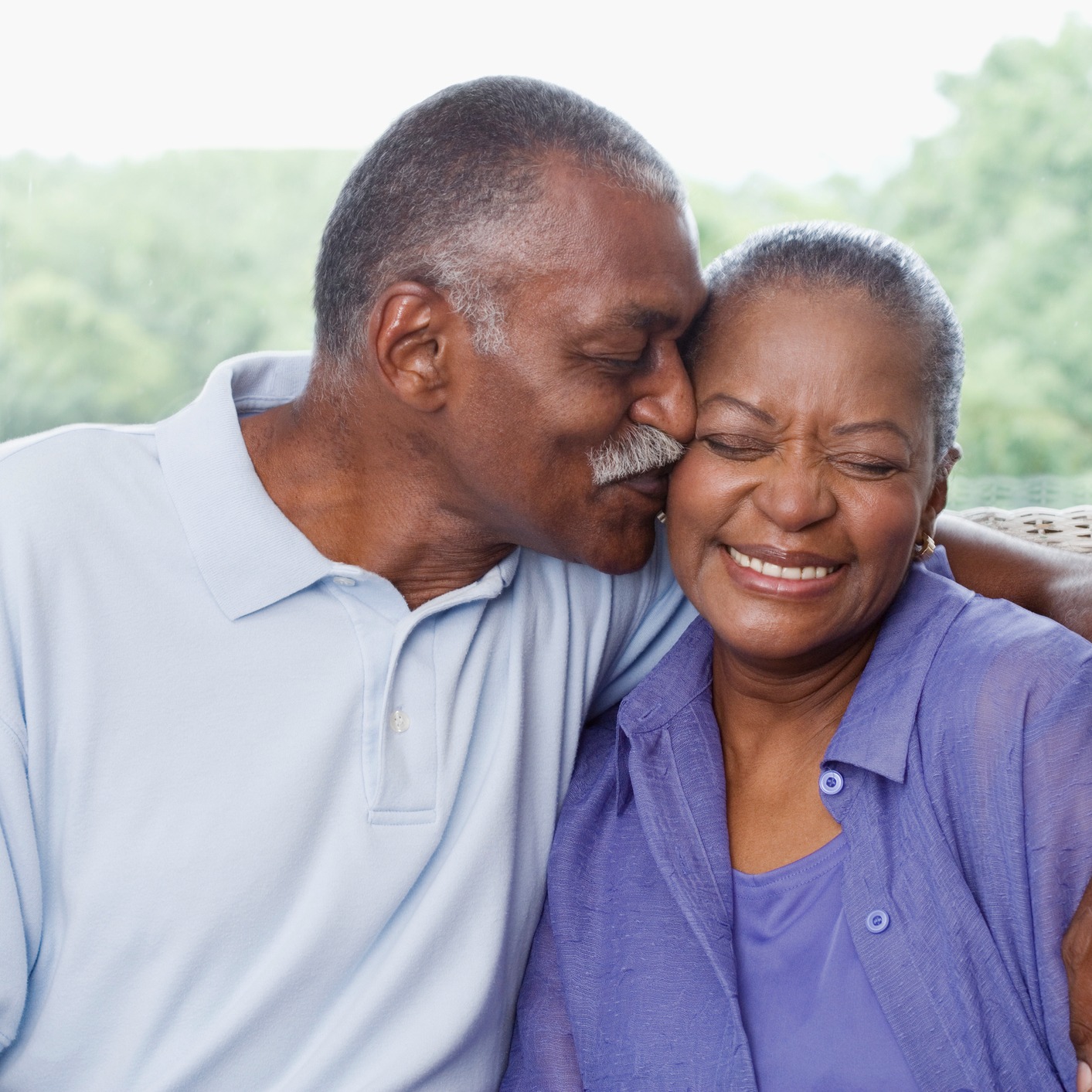 senior man kissing wife on the cheek