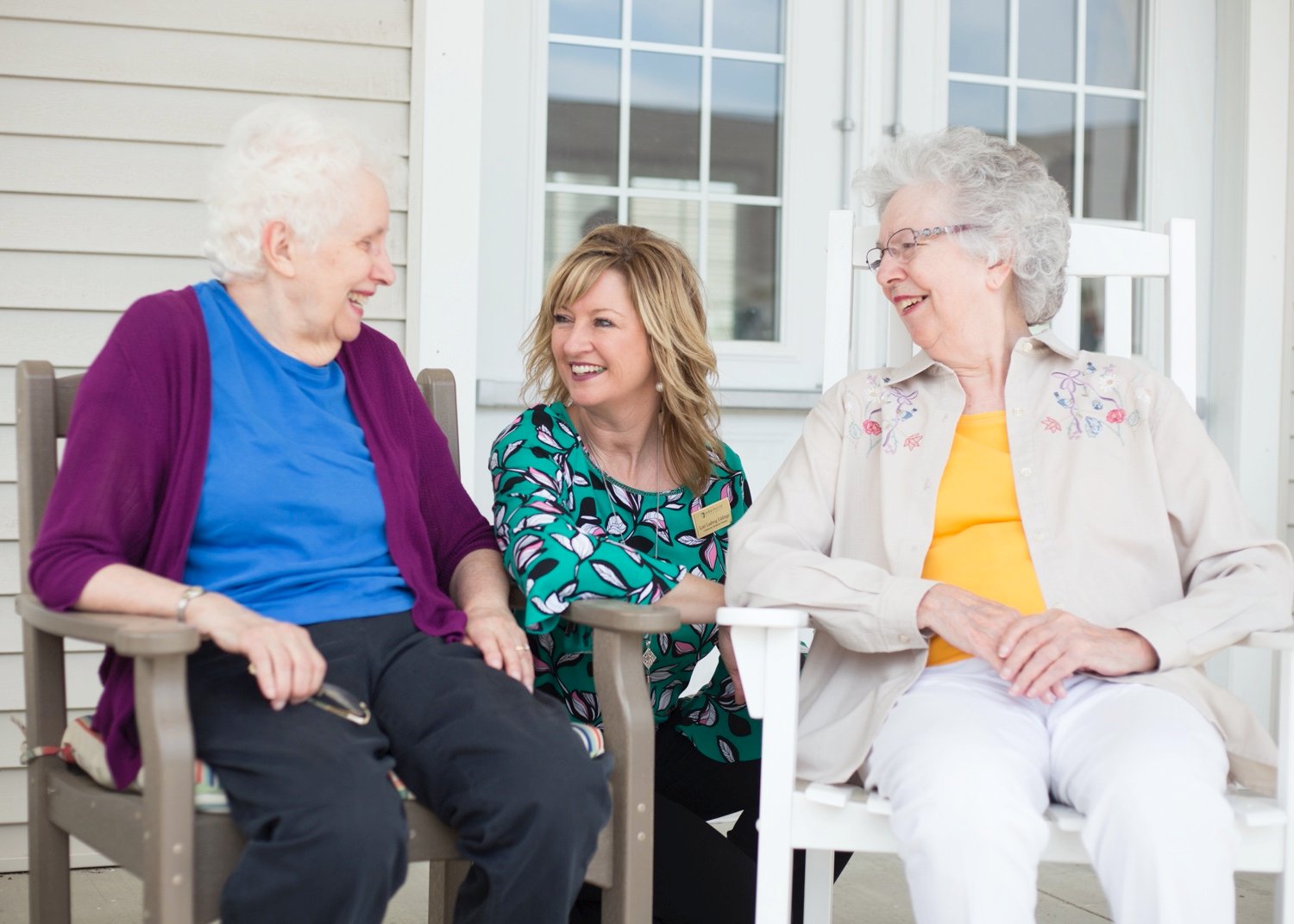 Senior women chatting outdoors with a team member