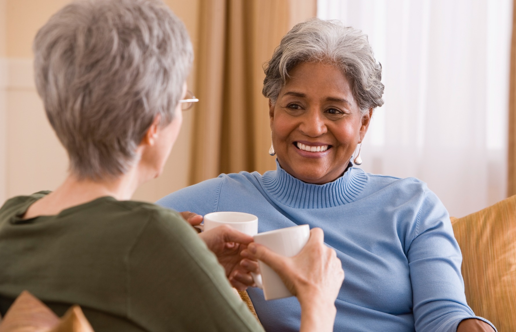 Women talking over coffee on couch