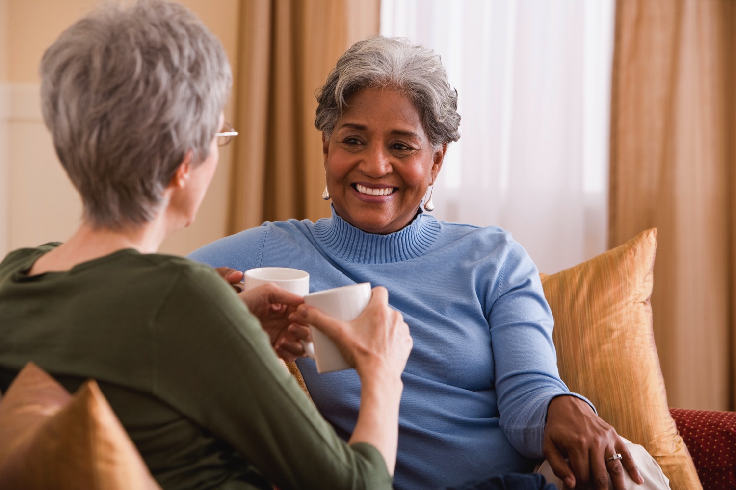 Two female senior residents having a conversation over tea.