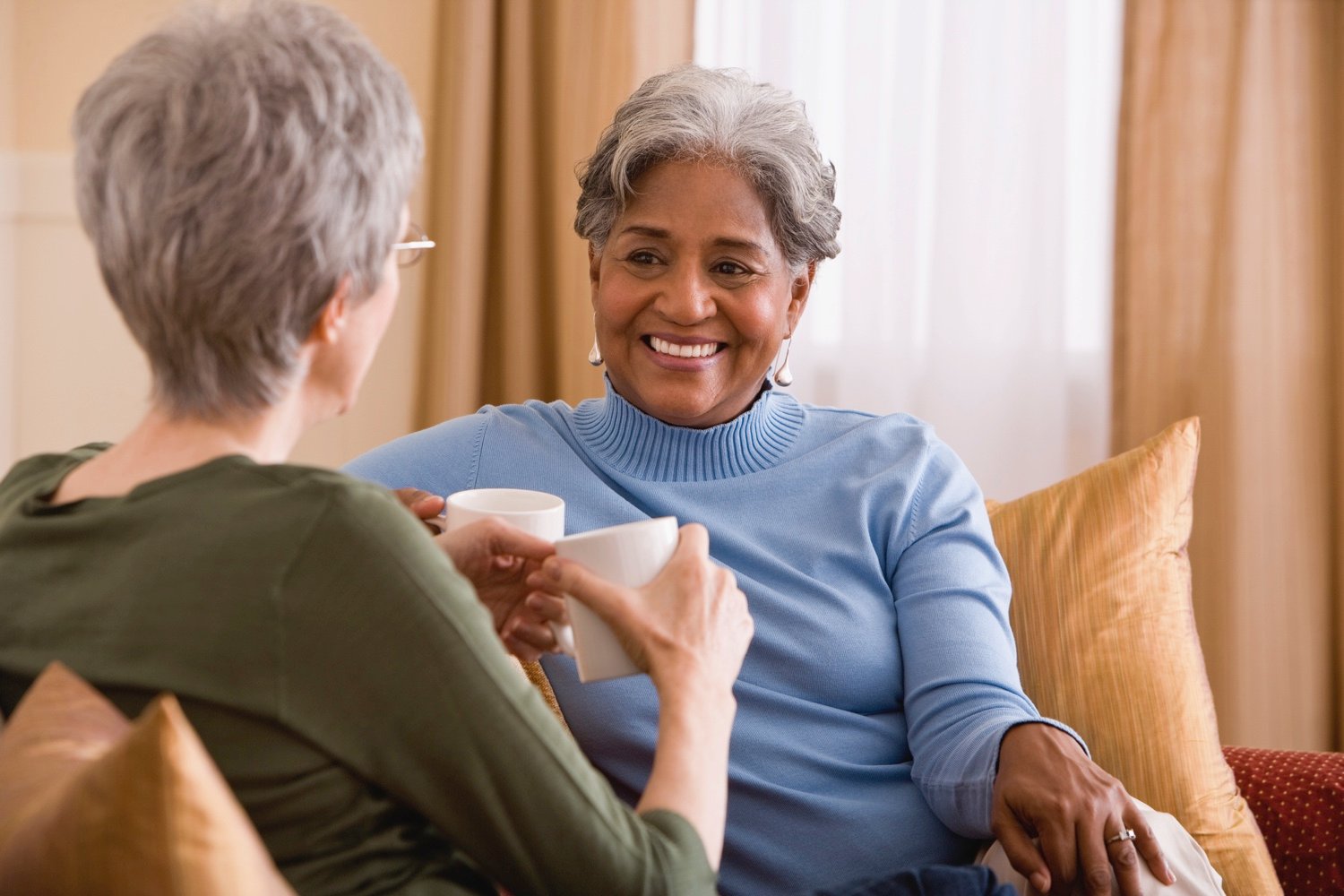 Women talking over coffee on a couch