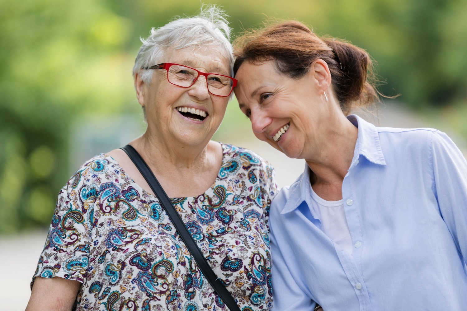 Two senior women laughing and walking
