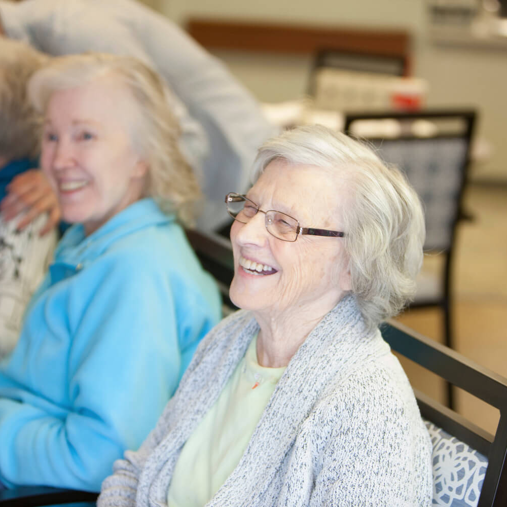 A group of residents smiling together in a living room
