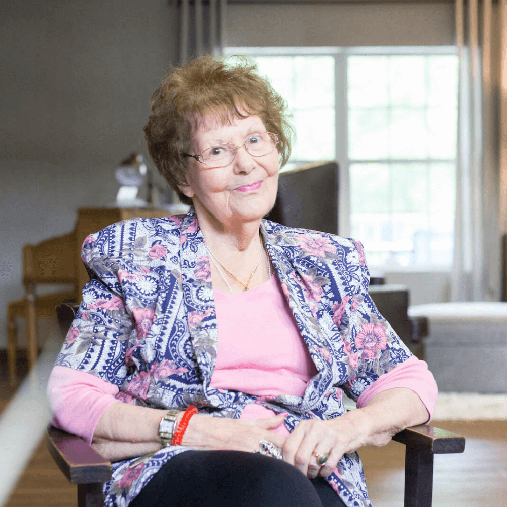 A resident smiling in her apartment