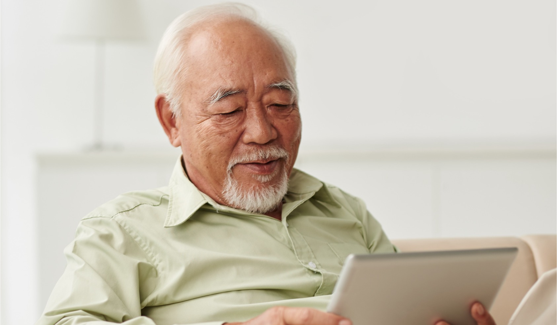 Senior man reading a tablet for information on senior living taxes