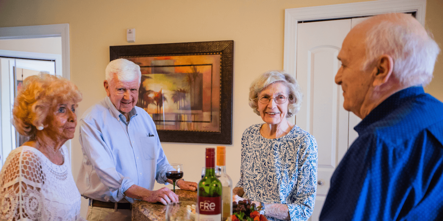 Retired residents of a senior living community are enjoying wine during a social event. 