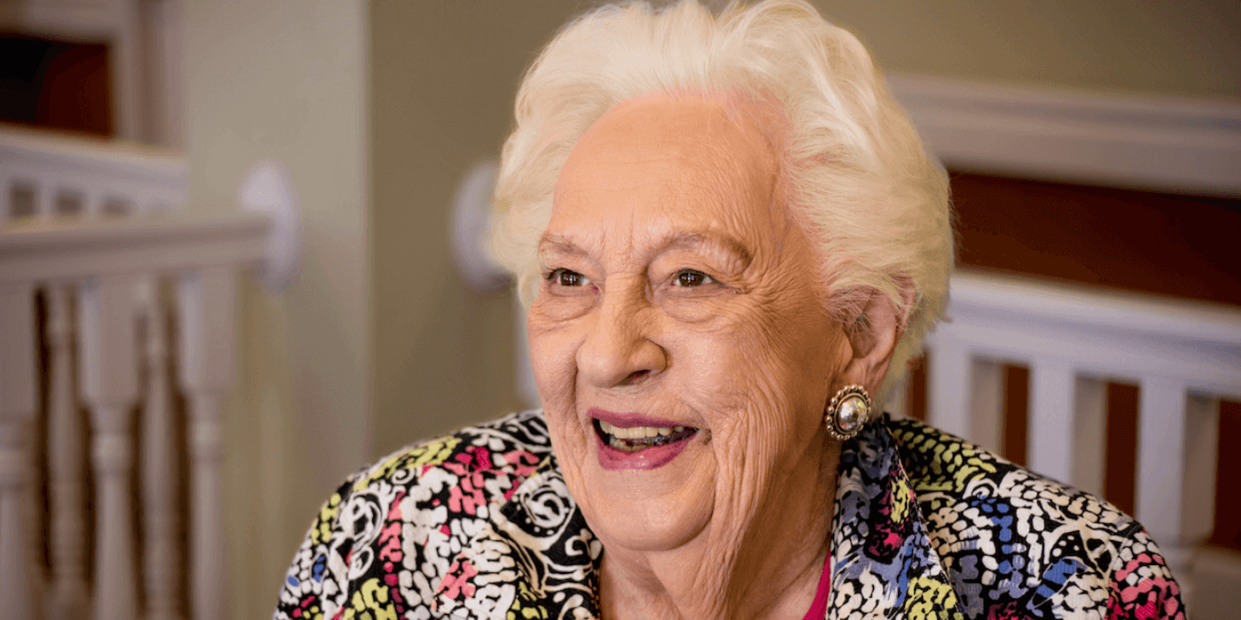 A senior resident smiling into a camera.