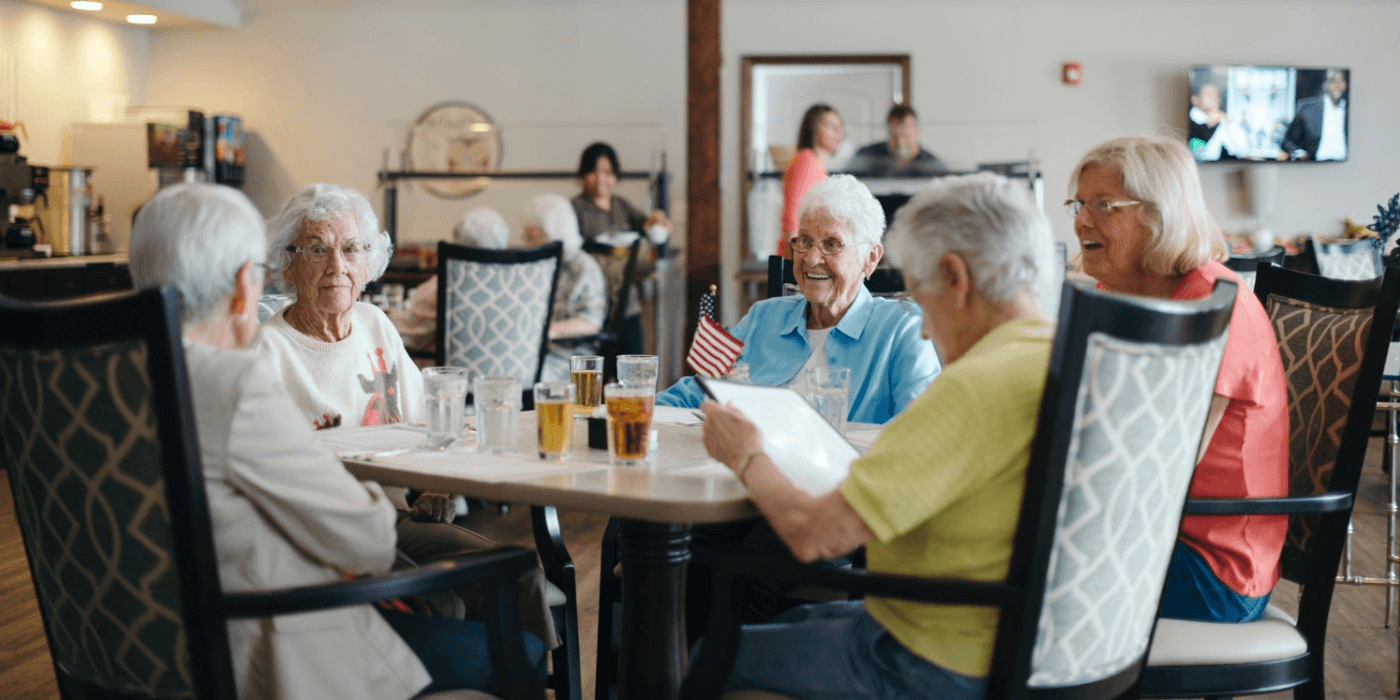 Five seniors socializing while dining together in a Cedarhurst community