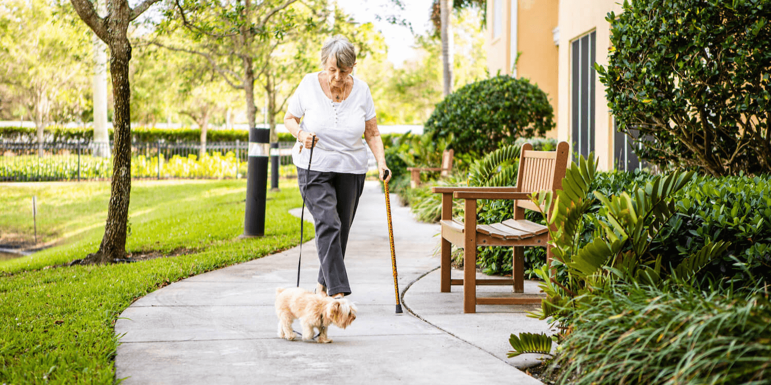 Senior resident woman walking her dog outside