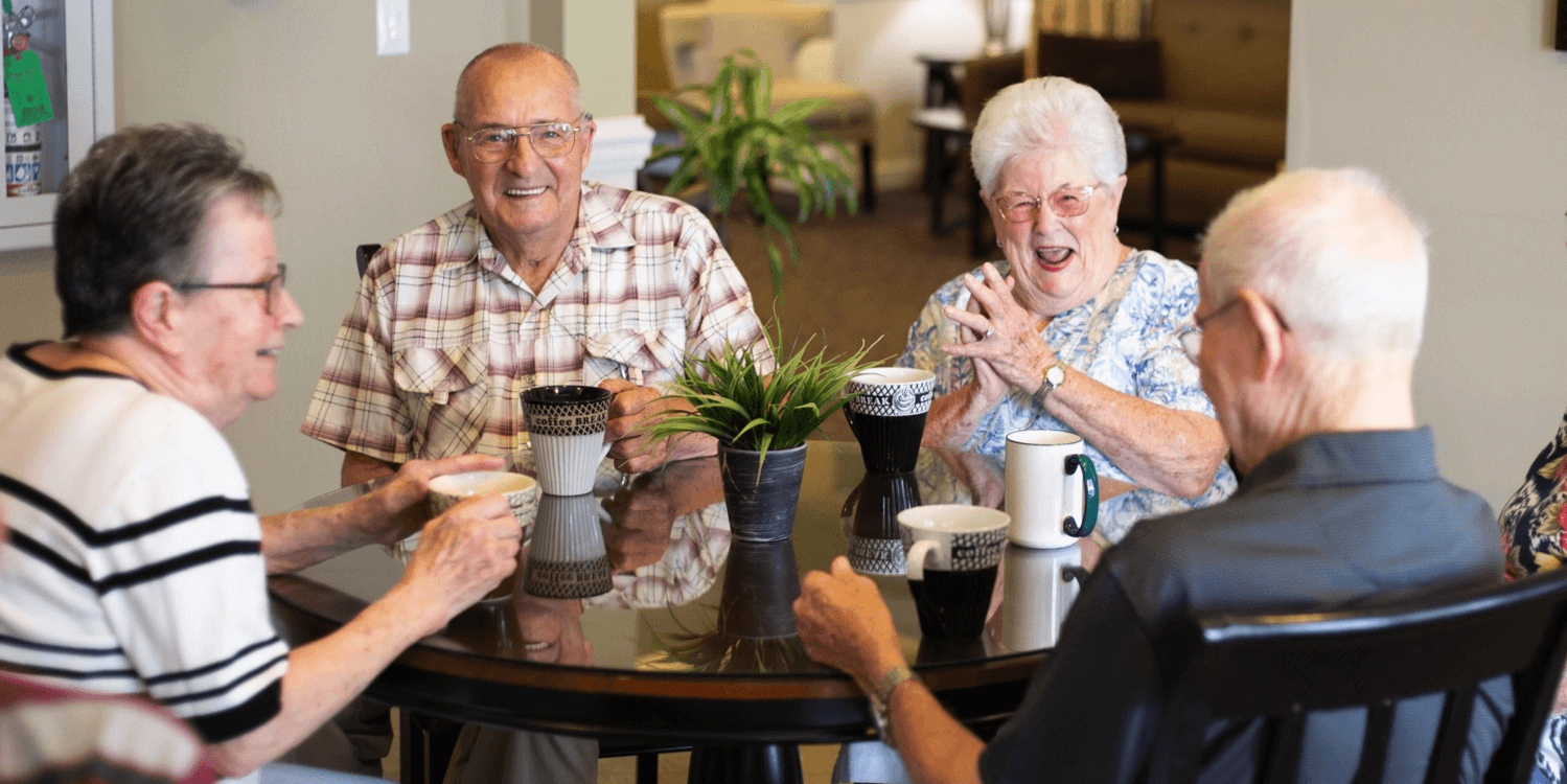 Four senior residents drinking coffee and socializing