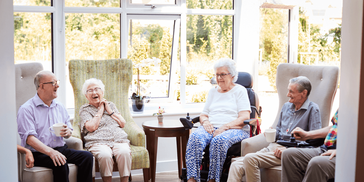 A group of senior assisted living residents enjoying coffee and conversation. 